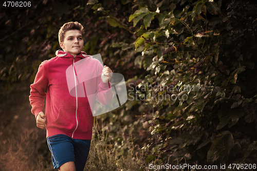Image of man jogging along a country road