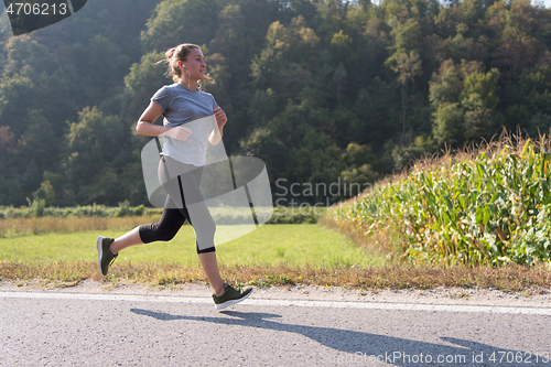 Image of woman jogging along a country road