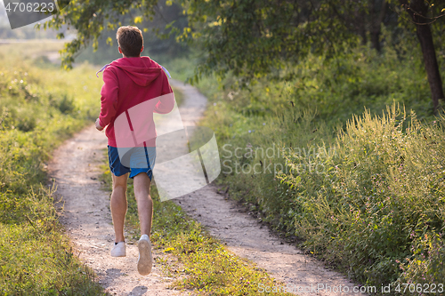 Image of man jogging along a country road