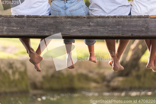 Image of people sitting at wooden bridge