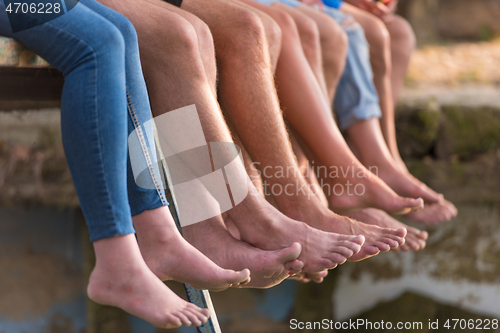 Image of people sitting at wooden bridge