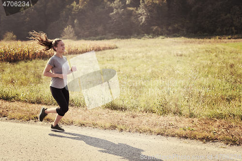 Image of woman jogging along a country road