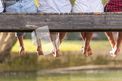 Image of people sitting at wooden bridge