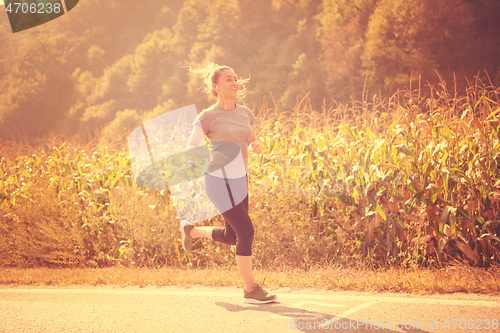 Image of woman jogging along a country road