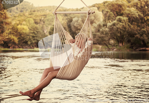 Image of blonde woman resting on hammock