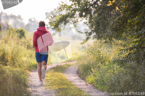 Image of man jogging along a country road