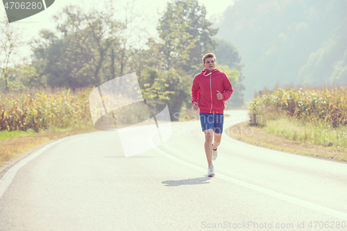 Image of man jogging along a country road