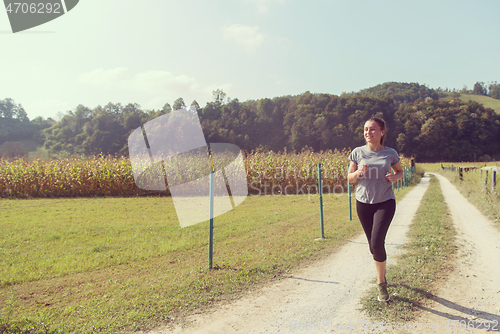 Image of woman jogging along a country road