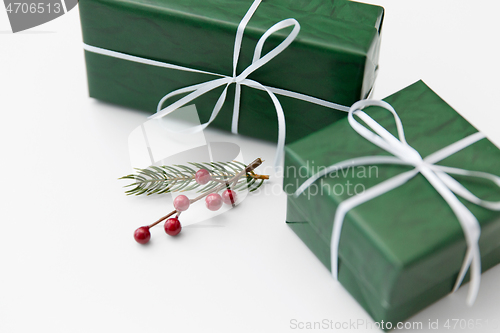 Image of green gift boxes and fir tree branch with berries