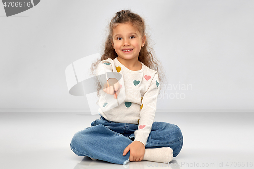 Image of smiling girl pointing finger to camera