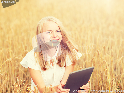 Image of happy young woman with tablet pc on cereal field