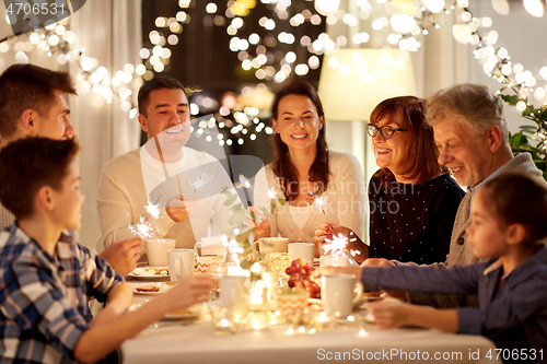 Image of family with sparklers having tea party at home