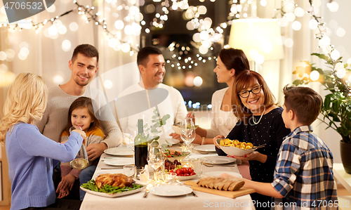 Image of happy family having dinner party at home