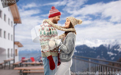 Image of couple in ugly christmas sweaters over ski resort