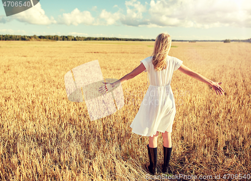 Image of happy young woman in white dress on cereal field