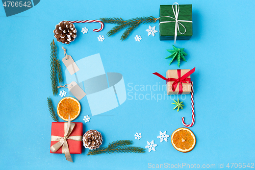 Image of frame of gifts, fir branches, tags and decorations