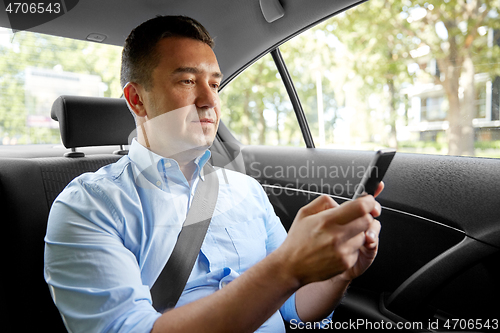 Image of passenger or businessman using smartphone in car