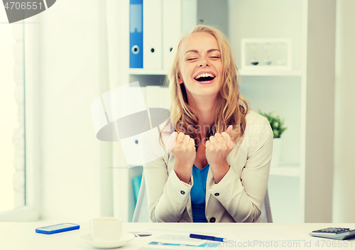 Image of happy businesswoman celebrating success at office