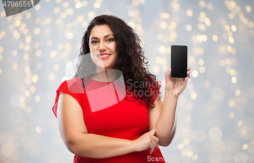 Image of happy woman in red dress showing smartphone