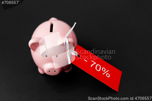 Image of piggy bank with red sale tag on black