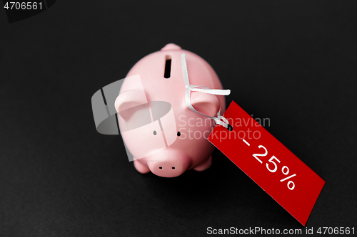 Image of piggy bank with red sale tag on black