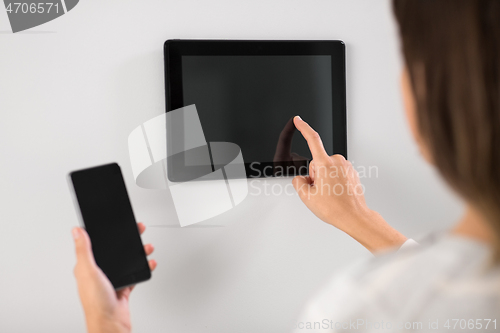 Image of woman using tablet computer and smartphone