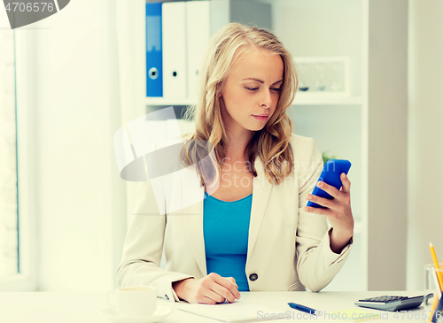 Image of businesswoman texting on smartphone at office