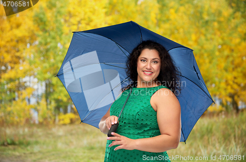 Image of happy woman with blue umbrella over autumn park