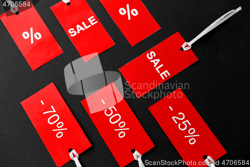 Image of red tags with discount signs on black background