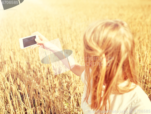 Image of close up of girl with smartphone on cereal field