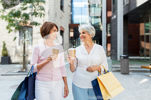 Image of senior women with shopping bags and coffee in city