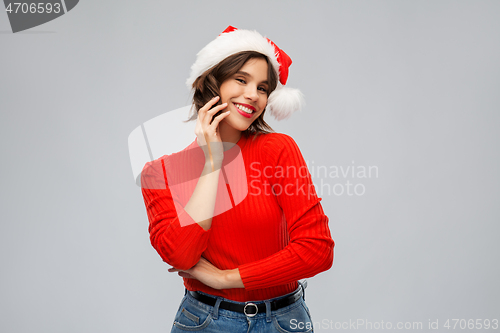 Image of happy young woman in santa hat on christmas