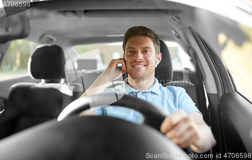 Image of man or driver with wireless earphones driving car