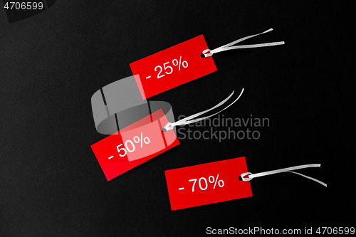 Image of red tags with discount signs on black background