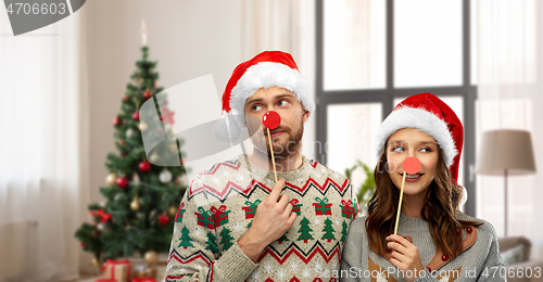 Image of couple with christmas party props in ugly sweaters