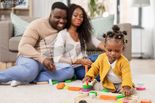 Image of african family playing with baby daughter at home