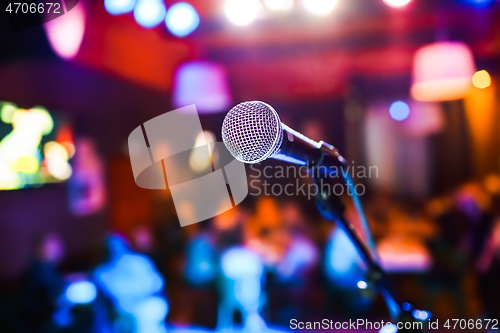 Image of Microphone on stage against a background of auditorium.