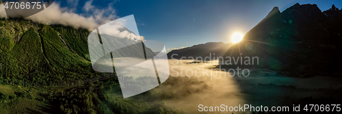 Image of Morning mist over the valley among the mountains in the sunlight