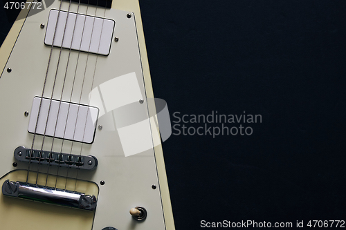 Image of White V shape electric guitar on dark grunge background.