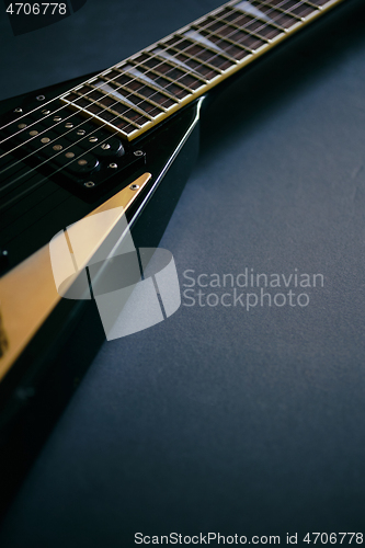 Image of Black V shape electric guitar on dark grunge background.