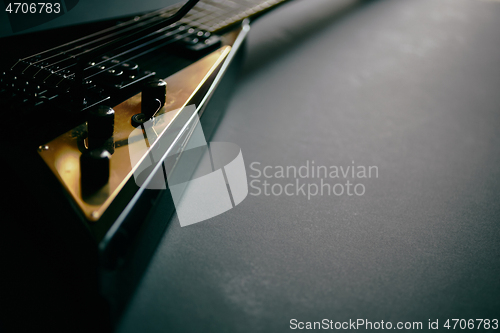 Image of Black V shape electric guitar on dark grunge background.