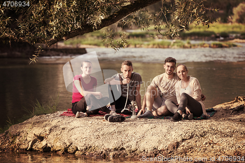 Image of friends smoking hookah on the river bank