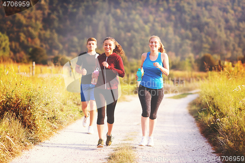 Image of young people jogging on country road