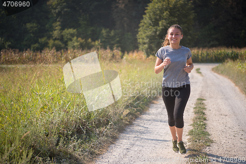 Image of woman jogging along a country road