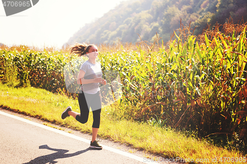 Image of woman jogging along a country road