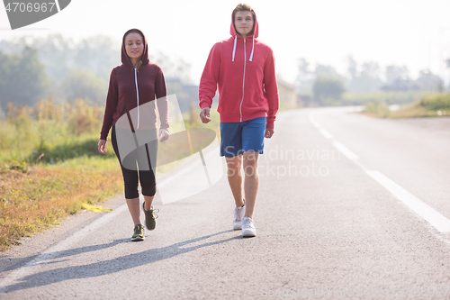 Image of young couple jogging along a country road