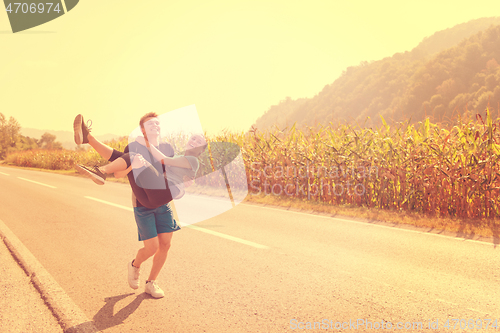 Image of happy couple jogging along a country road