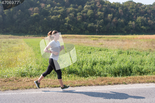 Image of woman jogging along a country road