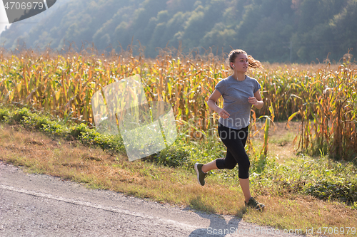 Image of woman jogging along a country road