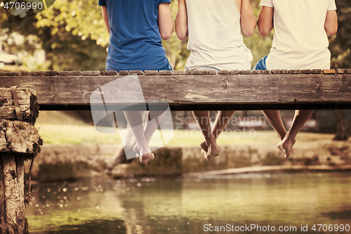 Image of people sitting at wooden bridge